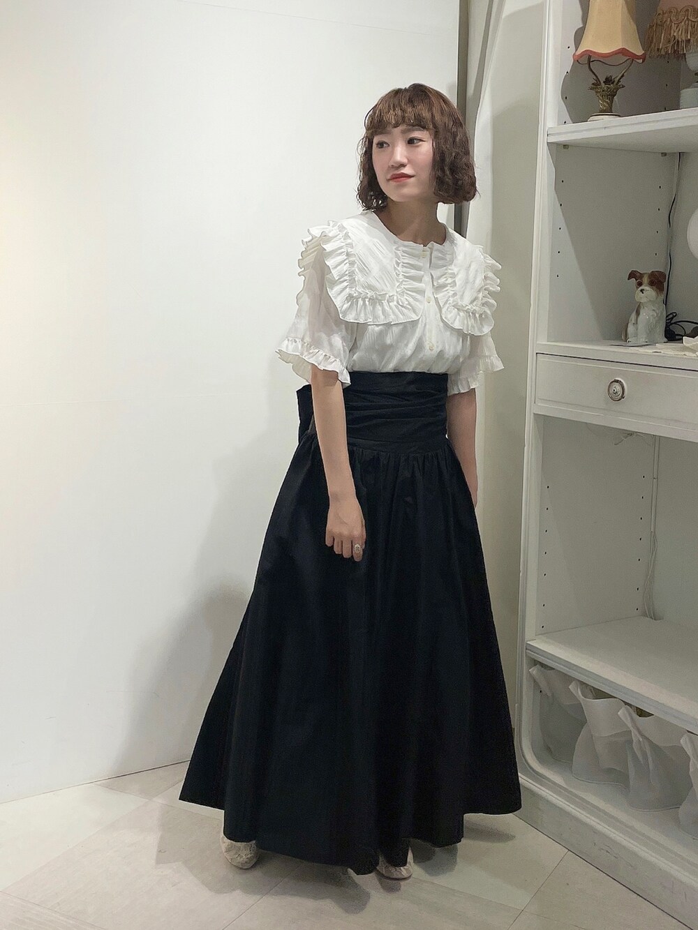 ホワイト系のシャツ/ブラウス、ブラック系のスカート、ホワイト系のパンプスを着用したレディースの春コーディネートの2枚目の写真