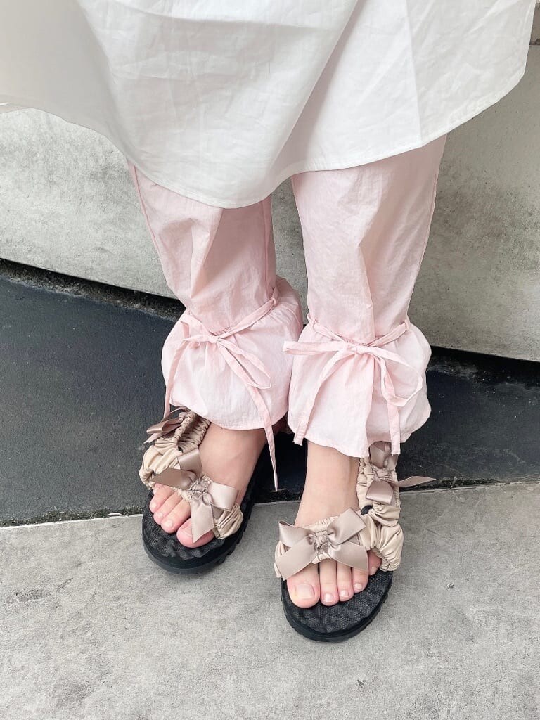 ホワイト系のワンピース、ベージュ系のサンダル、ピンク系のスラックスを着用したレディースの夏コーディネートの5枚目の写真