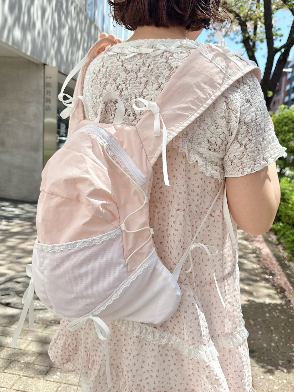 ホワイト系のTシャツ/カットソー、ピンク系のワンピース、ピンク系のバックパック/リュックを着用したレディースの春コーディネートの7枚目の写真