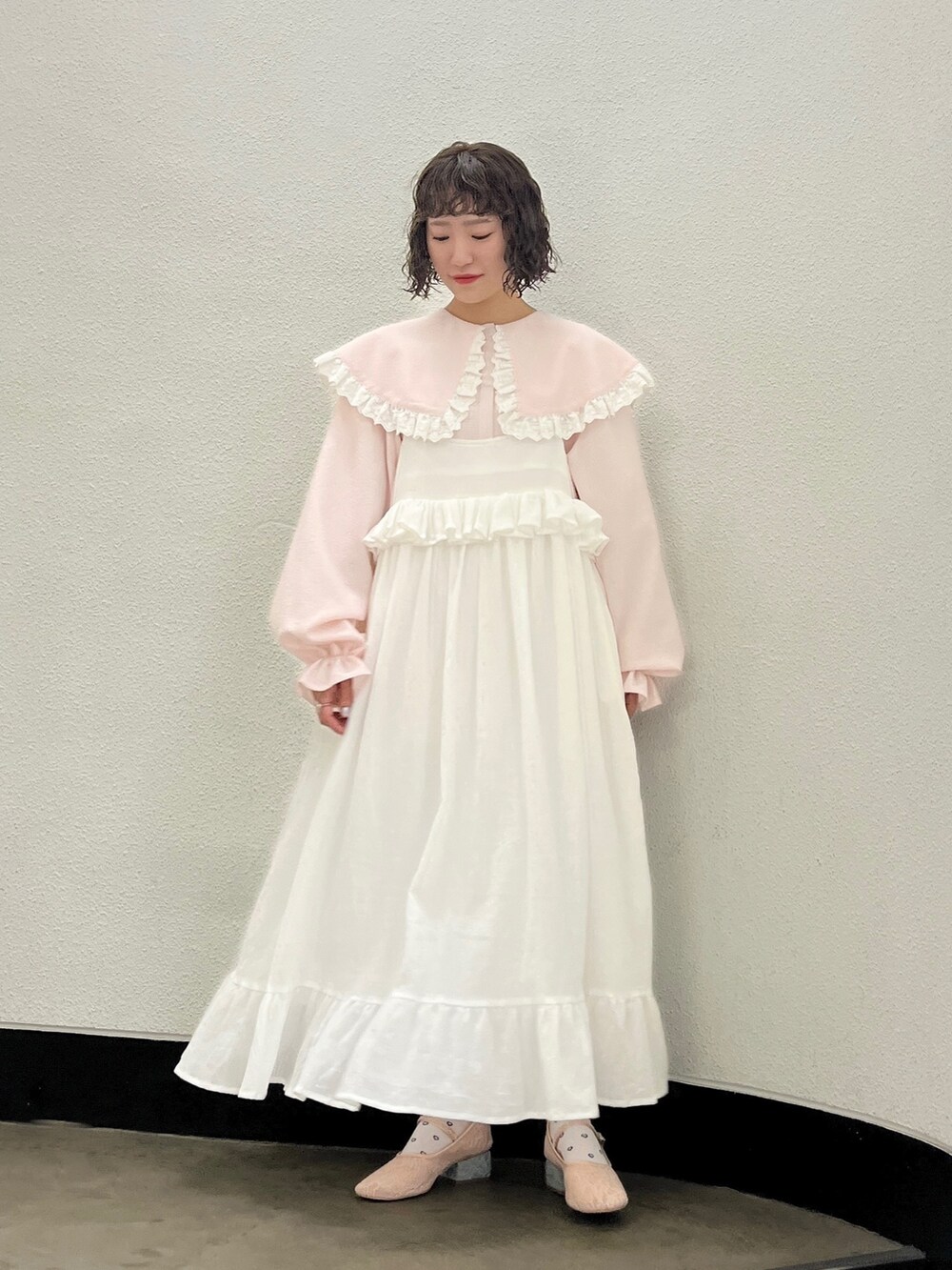 ピンク系のシャツ/ブラウス、ホワイト系のスカート、ピンク系のパンプスを着用したレディースの春コーディネートの2枚目の写真