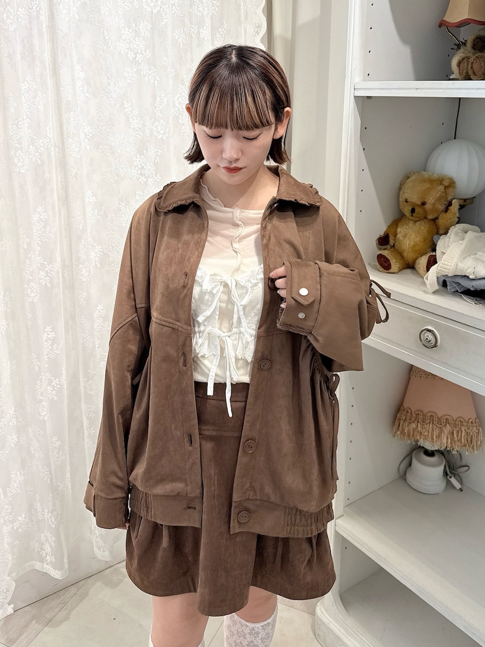 ブラウン系のスカート、ホワイト系のTシャツ/カットソー、ブラウン系のライダースジャケットを着用したレディースの夏コーディネートの5枚目の写真