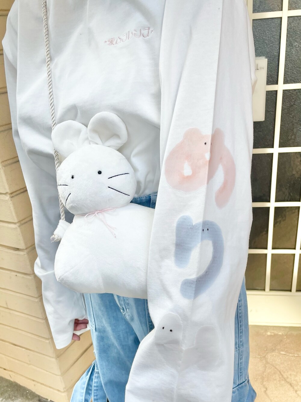 ホワイト系のTシャツ/カットソー、ホワイト系のショルダーバッグ、ブルー系のデニムパンツを着用したレディースの冬コーディネートの7枚目の写真