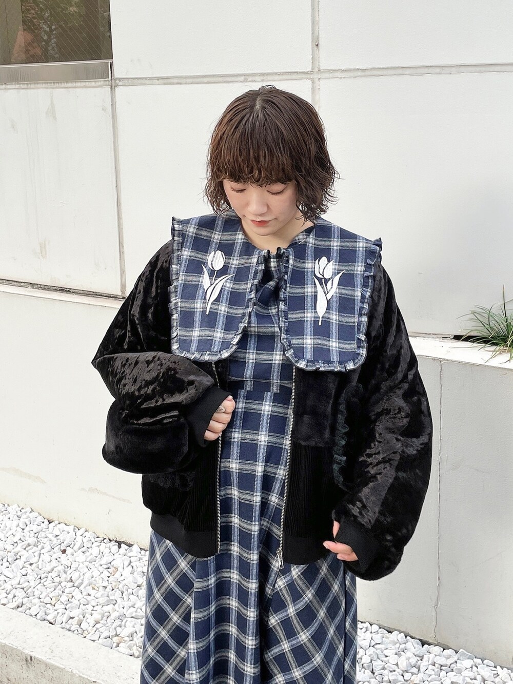 ブルー系のワンピース、ブラック系のブルゾン、ブラック系のスニーカーを着用したレディースの秋コーディネートの4枚目の写真