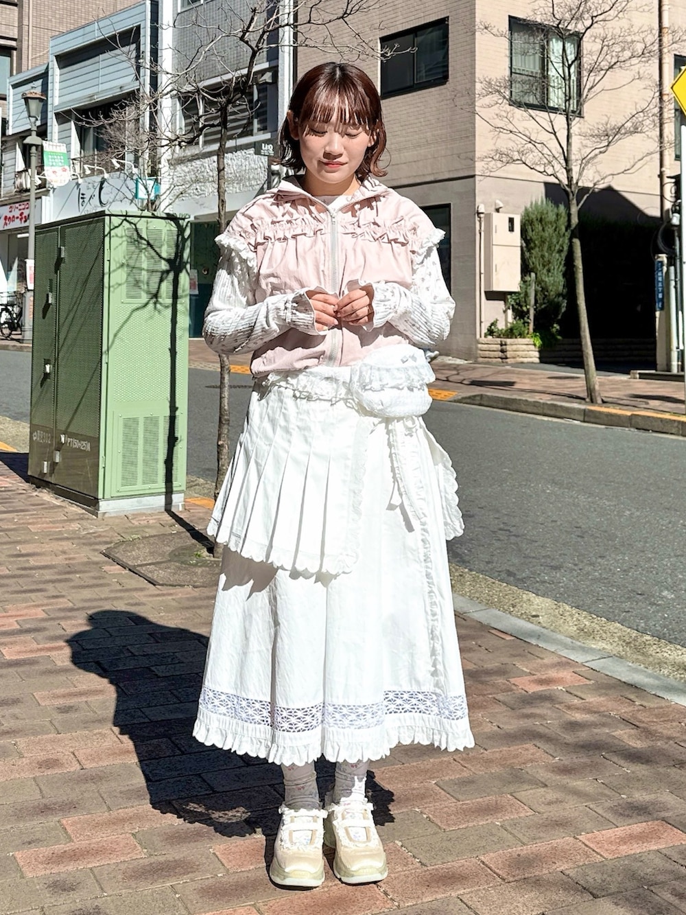 ピンク系のベスト、ピンク系のTシャツ/カットソー、ホワイト系のスカートを着用したレディースの春コーディネートの2枚目の写真