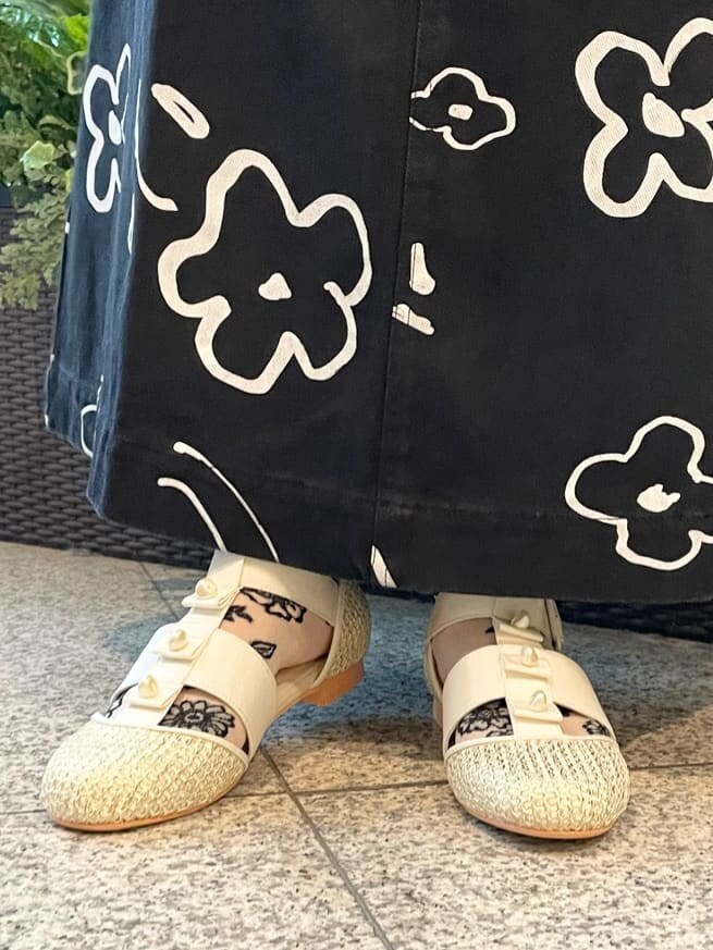 ベージュ系のニット/セーター、ホワイト系のチュニック、ブラック系のスカートを着用したレディースの夏コーディネートの7枚目の写真