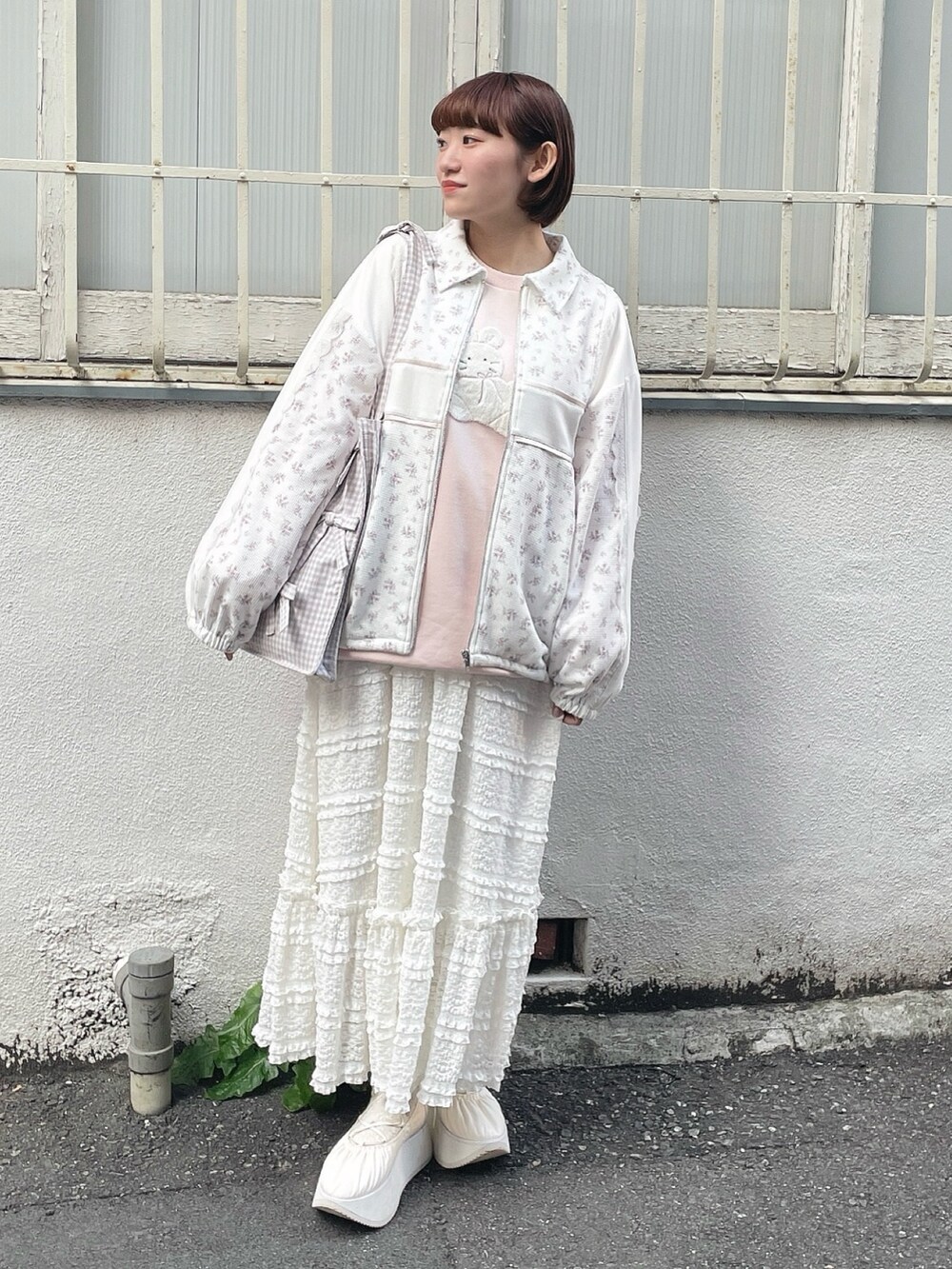 ピンク系のジャージ、ベージュ系のトートバッグ、ピンク系のスウェットを着用したレディースの冬コーディネートの2枚目の写真