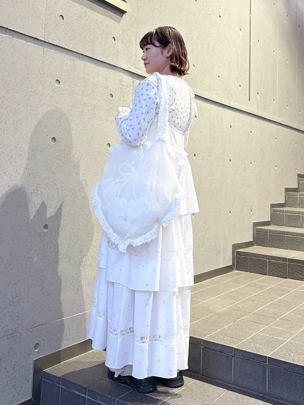 ブルー系のTシャツ/カットソー、ホワイト系のワンピース、ホワイト系のトートバッグを着用したレディースの冬コーディネートの3枚目の写真