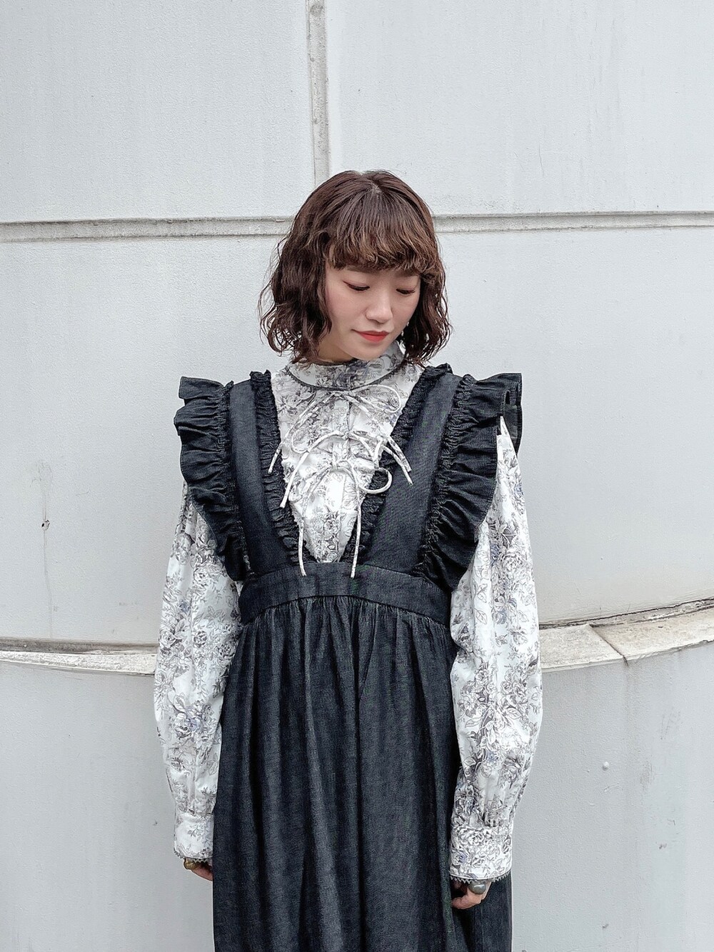 グレー系のシャツ/ブラウス、ブラック系のワンピース、ホワイト系のパンプスを着用したレディースの冬コーディネートの4枚目の写真