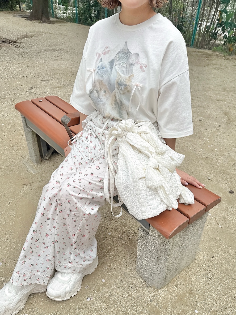 ホワイト系のTシャツ/カットソー、ホワイト系のスラックス、ホワイト系のトートバッグを着用したレディースの春コーディネートの3枚目の写真