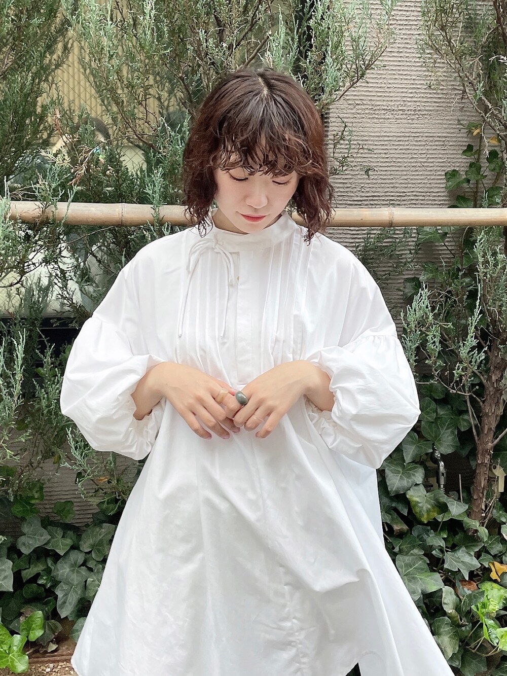 ホワイト系のワンピース、ホワイト系のスラックス、ベージュ系のブーツを着用したレディースの冬コーディネートの4枚目の写真