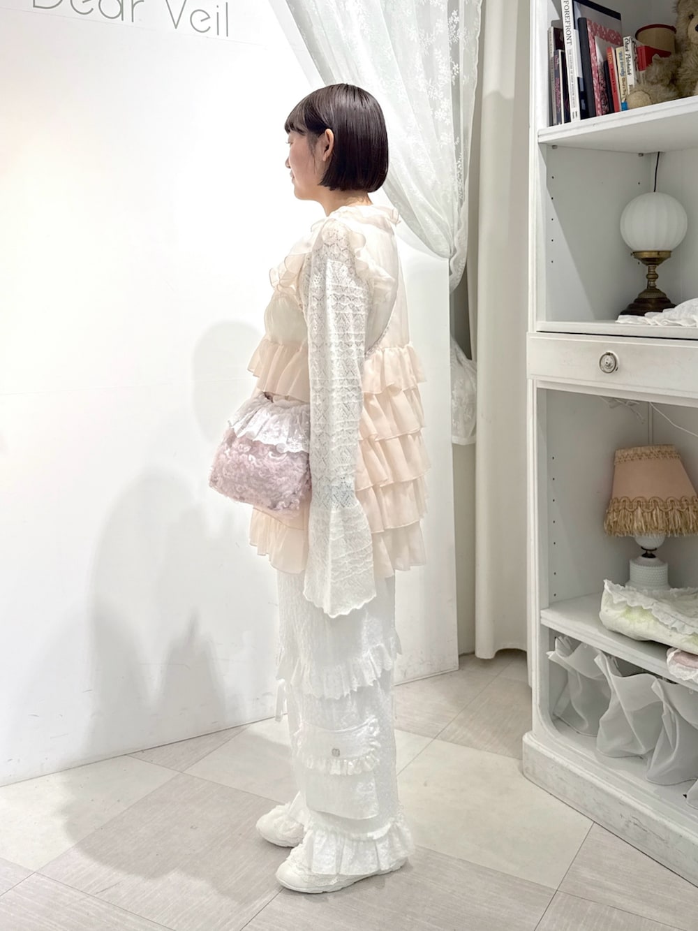 ピンク系のシャツ/ブラウス、ホワイト系のニット/セーター、ピンク系のハンドバッグを着用したレディースの夏コーディネートの2枚目の写真