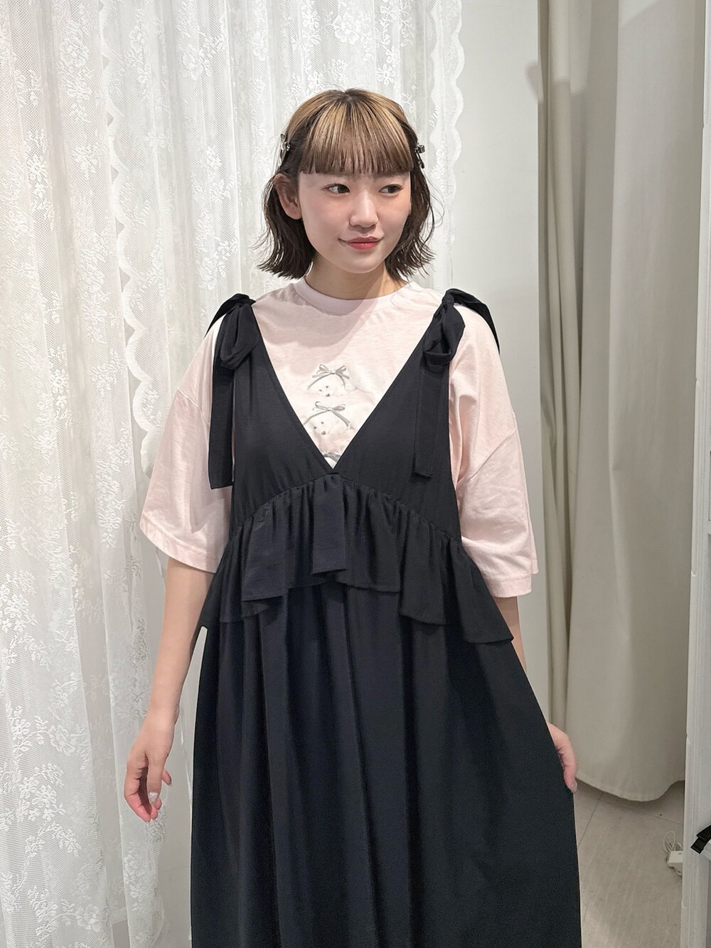 ピンク系のTシャツ/カットソー、ブラック系のワンピース、ブラック系のサンダルを着用したレディースの春コーディネートの5枚目の写真