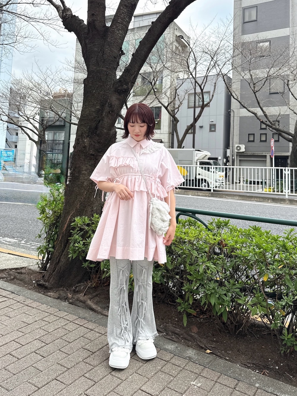 ブルー系のショルダーバッグ、ピンク系のワンピース、グレー系のその他パンツを着用したレディースの春コーディネートの2枚目の写真