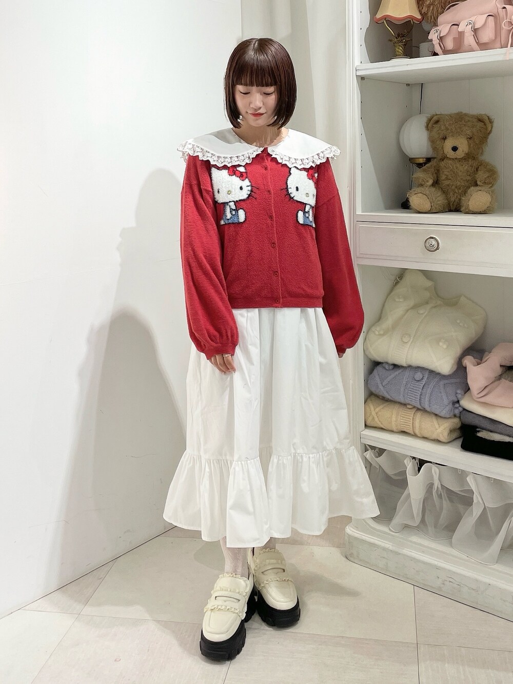 ホワイト系のワンピース、レッド系のカーディガン/ボレロ、ホワイト系のローファーを着用したレディースの秋コーディネートの2枚目の写真