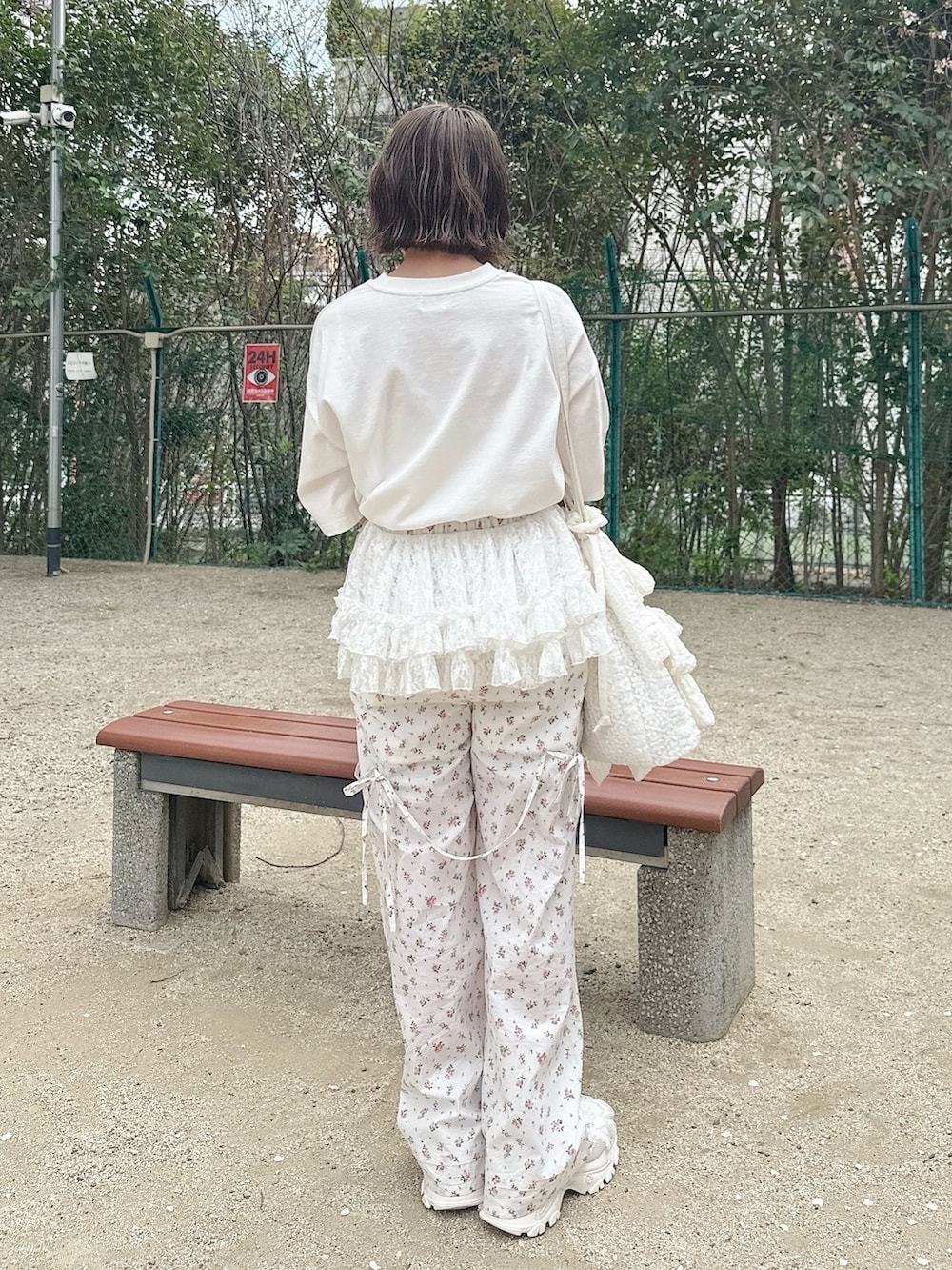 ホワイト系のTシャツ/カットソー、ホワイト系のスラックス、ホワイト系のトートバッグを着用したレディースの春コーディネートの5枚目の写真