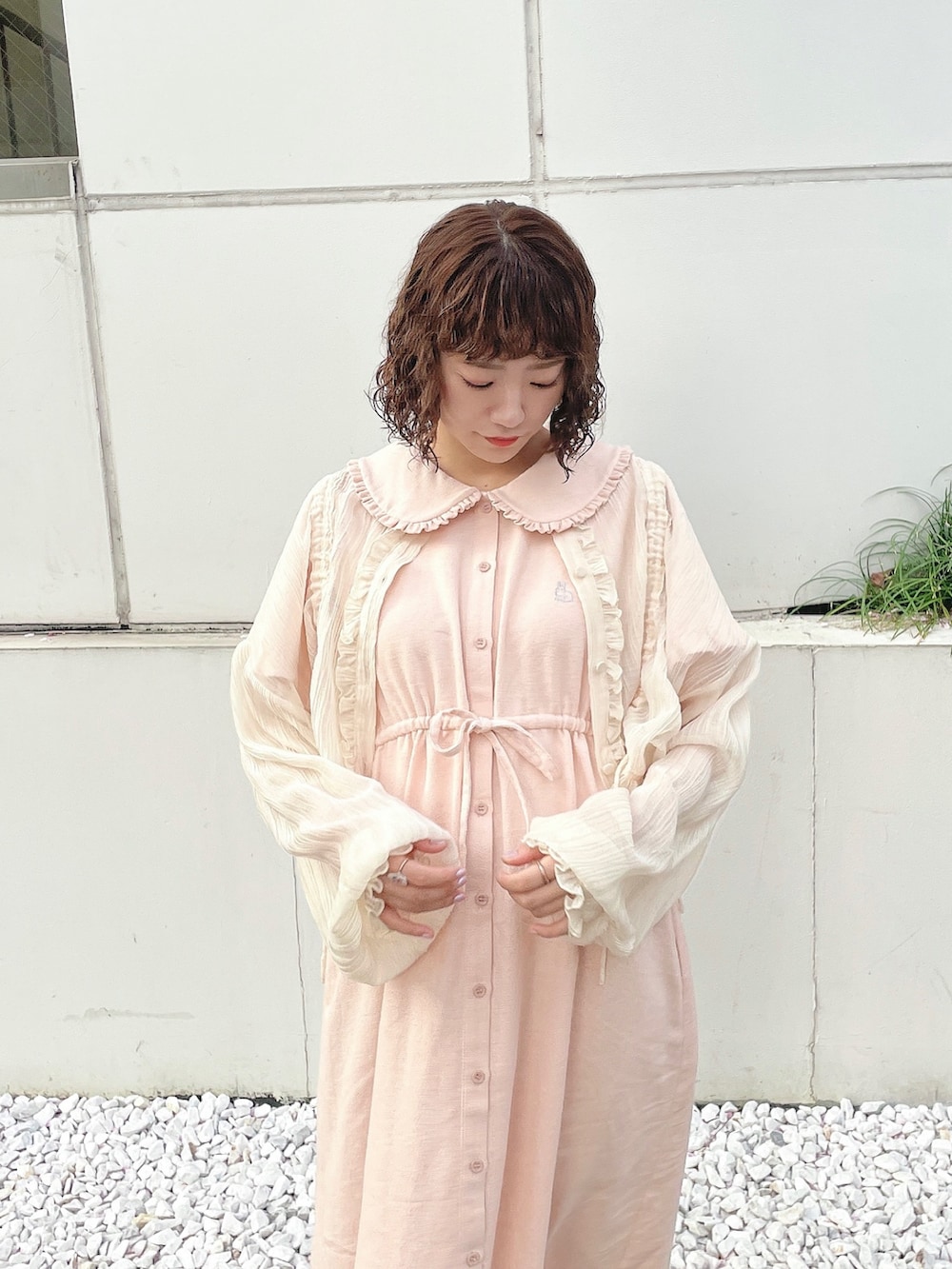 ベージュ系のシャツ/ブラウス、ピンク系のワンピース、ホワイト系のサンダルを着用したレディースの春コーディネートの3枚目の写真