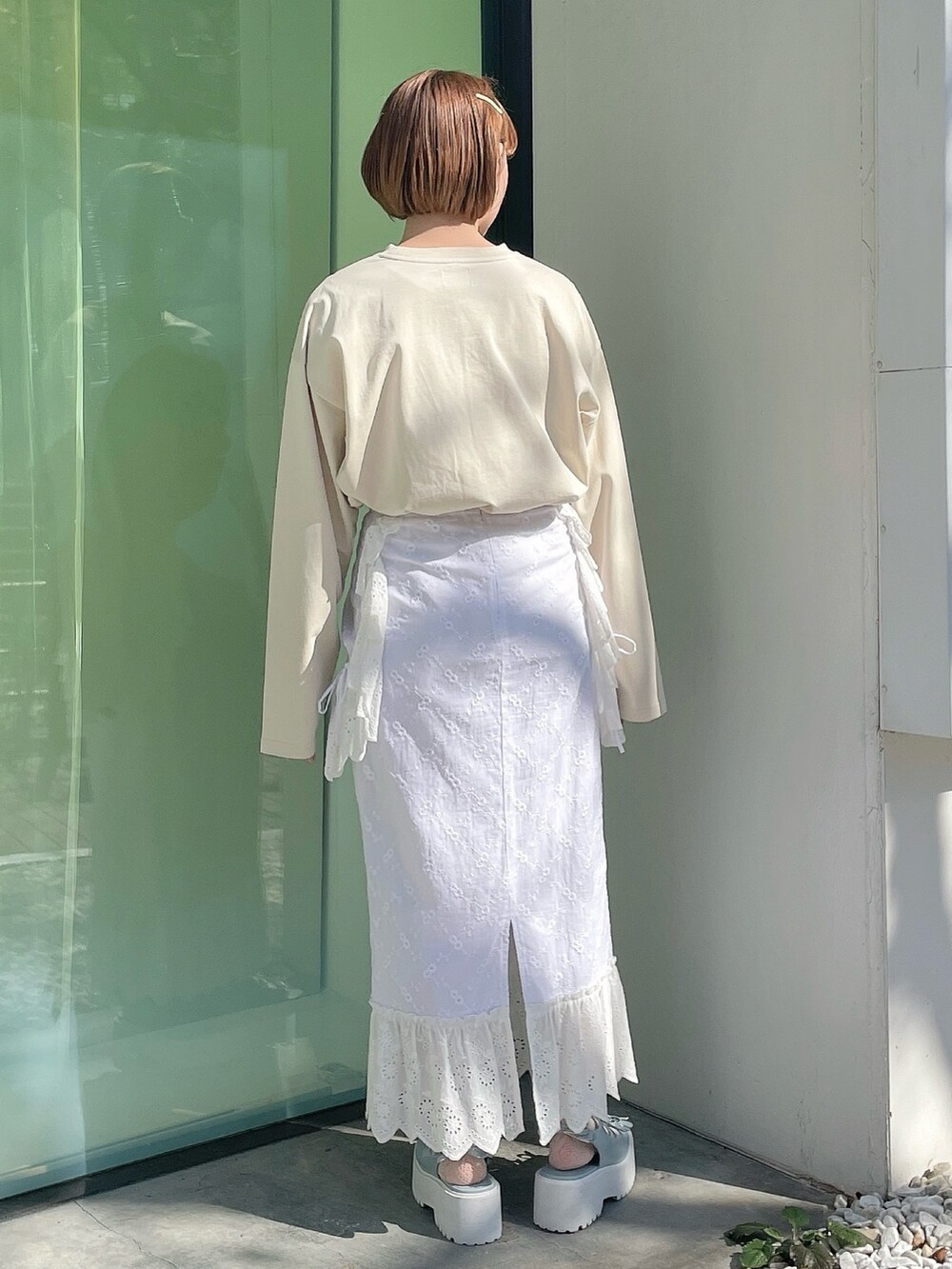 ホワイト系のスカート、ブルー系のサンダル、ベージュ系のTシャツ/カットソーを着用したレディースの冬コーディネートの3枚目の写真