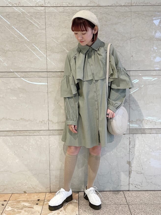 グリーン系のワンピース、ホワイト系のその他シューズ、ホワイト系のショルダーバッグを着用したレディースの冬コーディネートの2枚目の写真