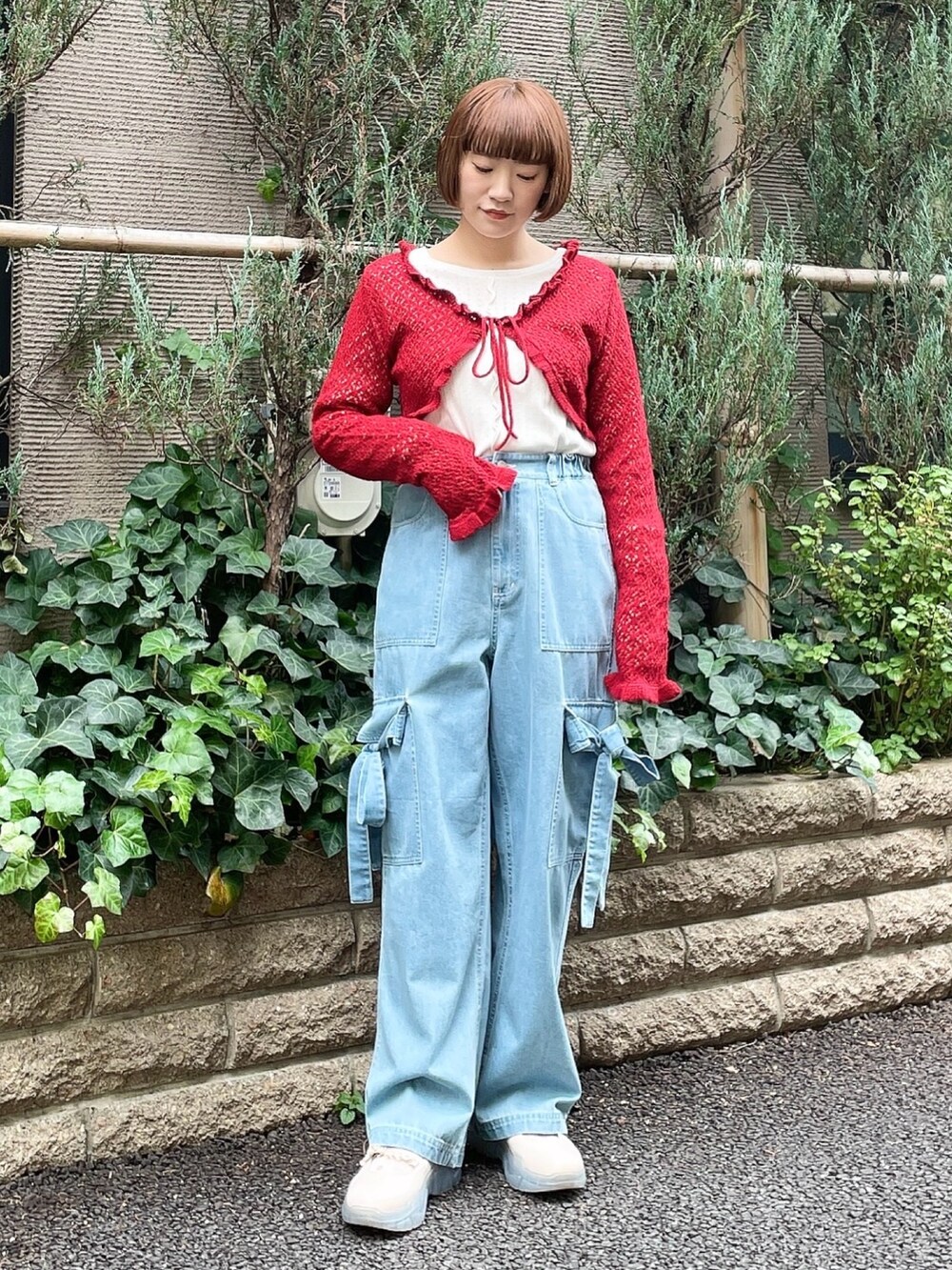 ブルー系のデニムパンツ、レッド系のカーディガン/ボレロ、ホワイト系のTシャツ/カットソーを着用したレディースの冬コーディネートの2枚目の写真