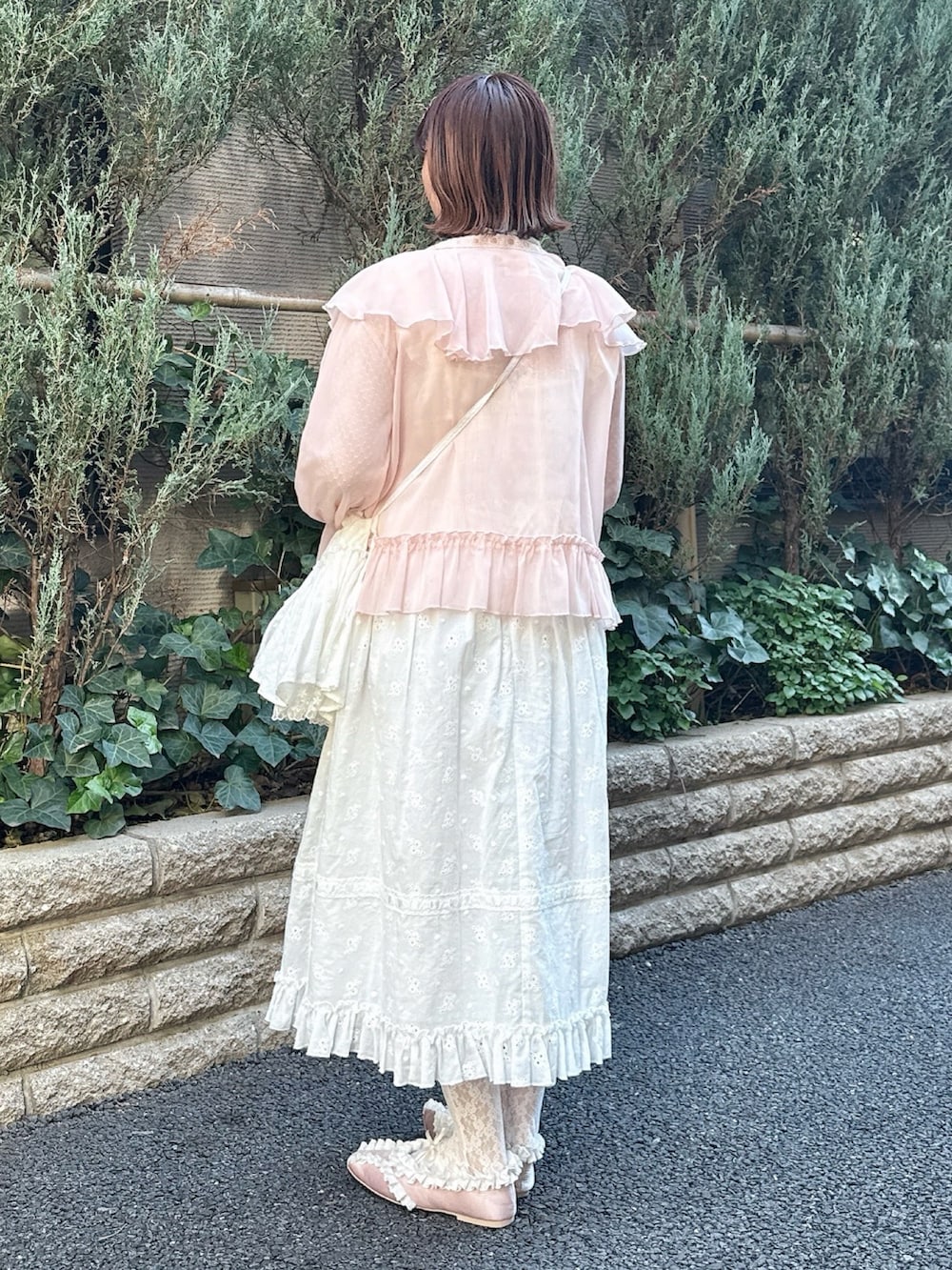 ホワイト系のTシャツ/カットソー、ピンク系のカーディガン/ボレロ、ホワイト系のワンピースを着用したレディースの冬コーディネートの3枚目の写真