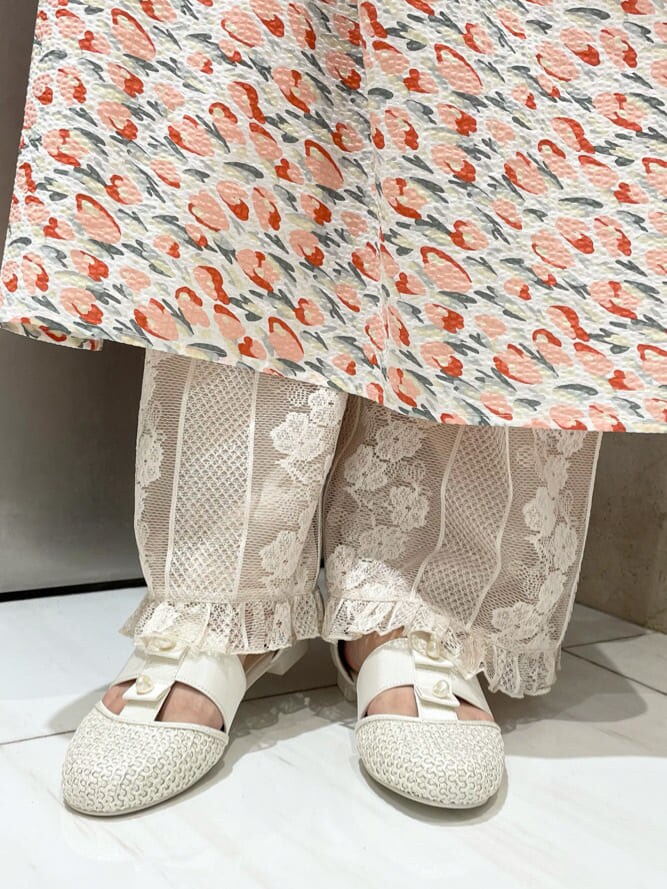 レッド系のワンピース、ホワイト系のその他パンツ、ホワイト系のパンプスを着用したレディースの夏コーディネートの5枚目の写真