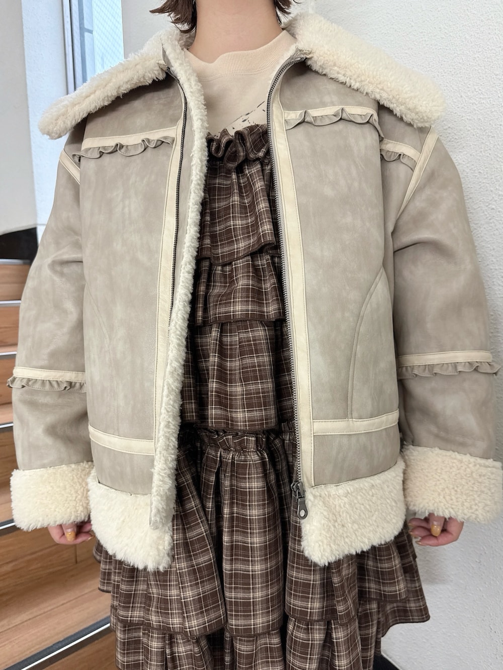 ブラウン系のワンピース、ベージュ系のムートンコート、ベージュ系のスウェットを着用したレディースの秋コーディネートの7枚目の写真