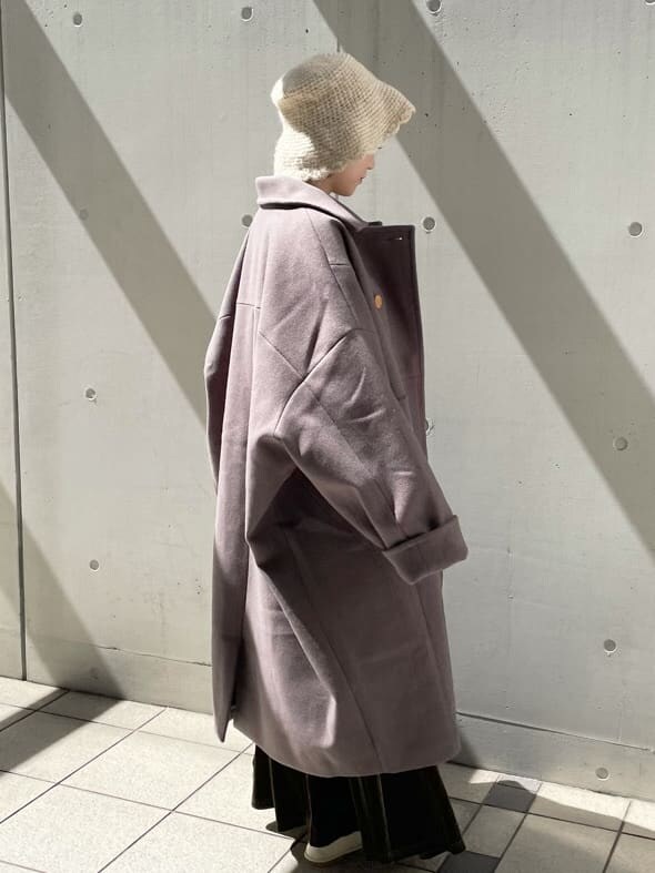 グリーン系のチェスターコート、ホワイト系のその他シューズ、ベージュ系のスカートを着用したレディースの秋コーディネートの5枚目の写真