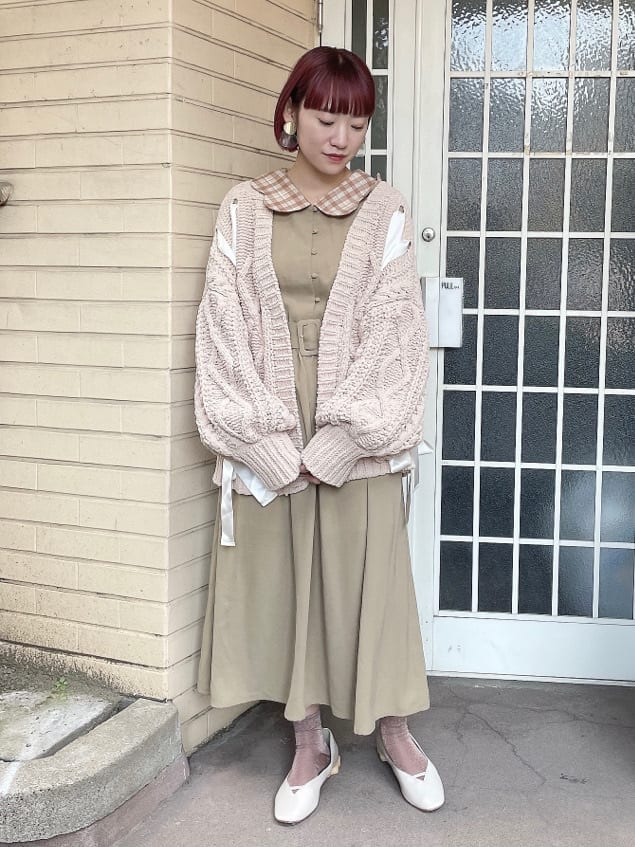 ベージュ系のワンピース、ブラウン系のハンドバッグ、ホワイト系のパンプスを着用したレディースの秋コーディネートの3枚目の写真