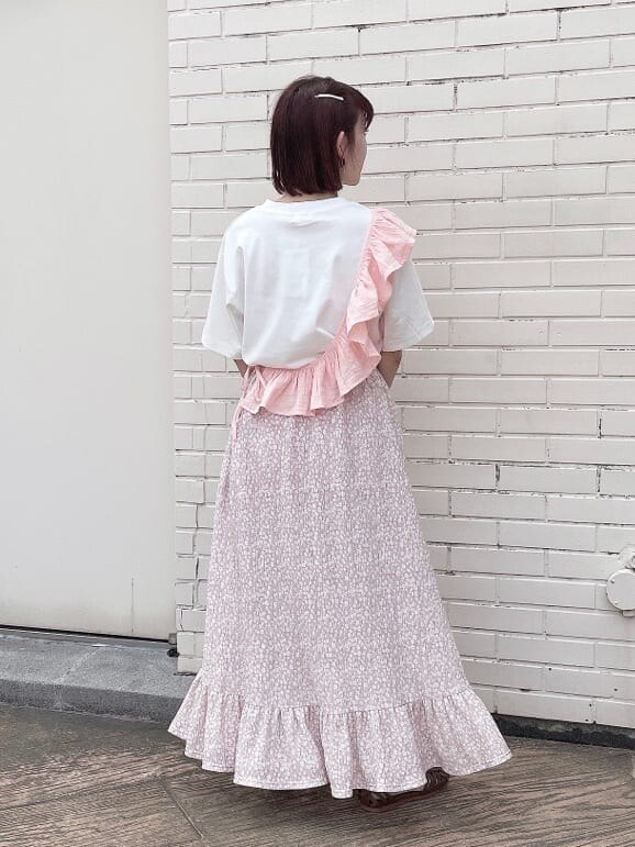 ピンク系のスカート、ベージュ系のパンプス、ホワイト系のTシャツ/カットソーを着用したレディースの夏コーディネートの3枚目の写真