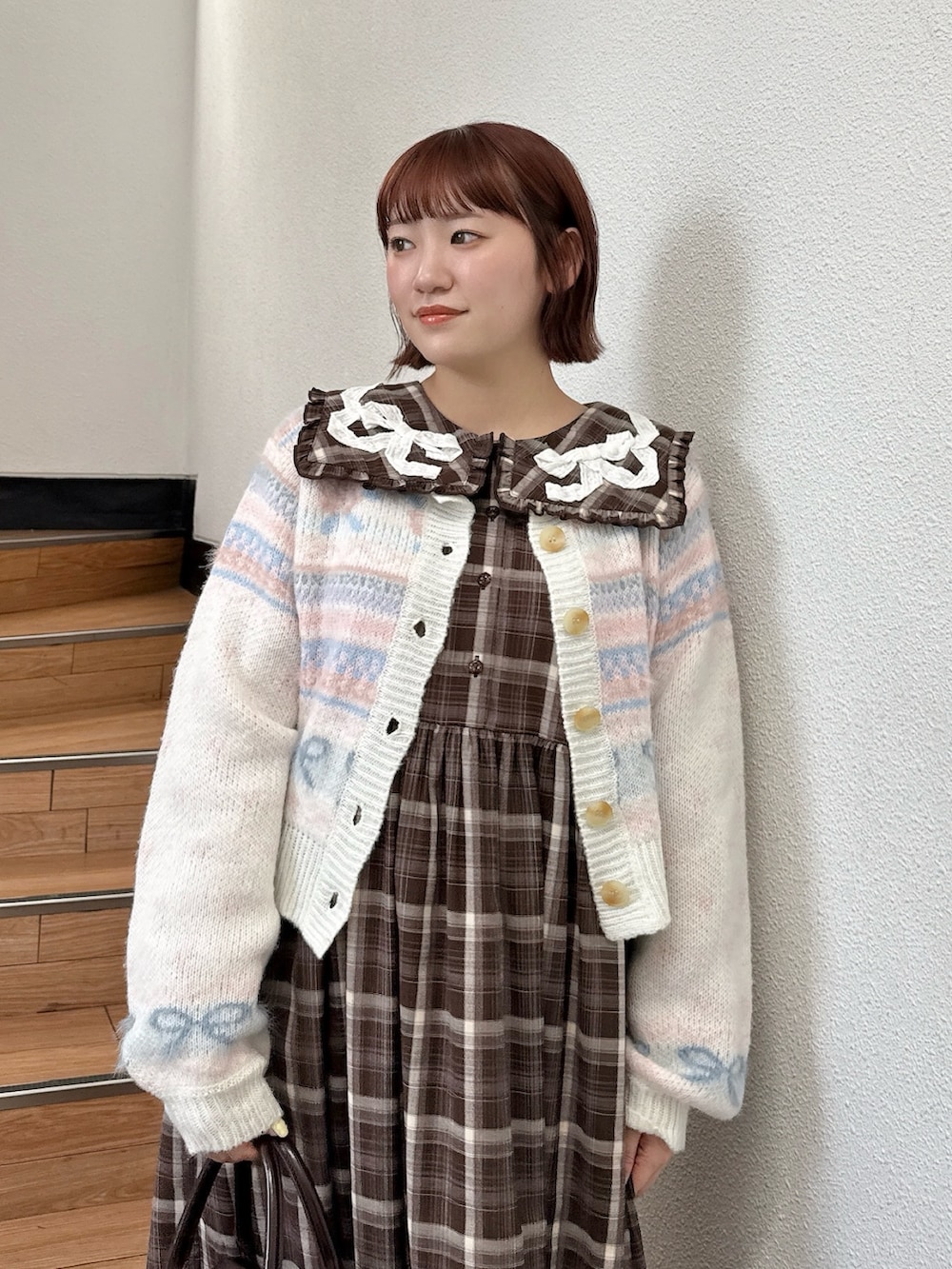 ホワイト系のカーディガン/ボレロ、ブラウン系のワンピース、ブラウン系のハンドバッグを着用したレディースの夏コーディネートの4枚目の写真