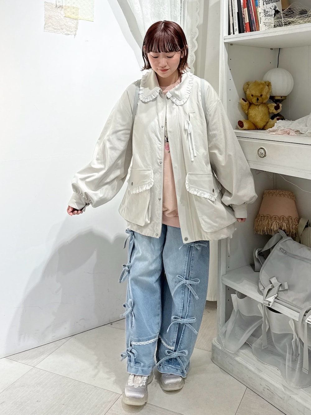 ホワイト系のブルゾン、ホワイト系のバックパック/リュック、ブルー系のデニムパンツを着用したレディースの冬コーディネートの2枚目の写真