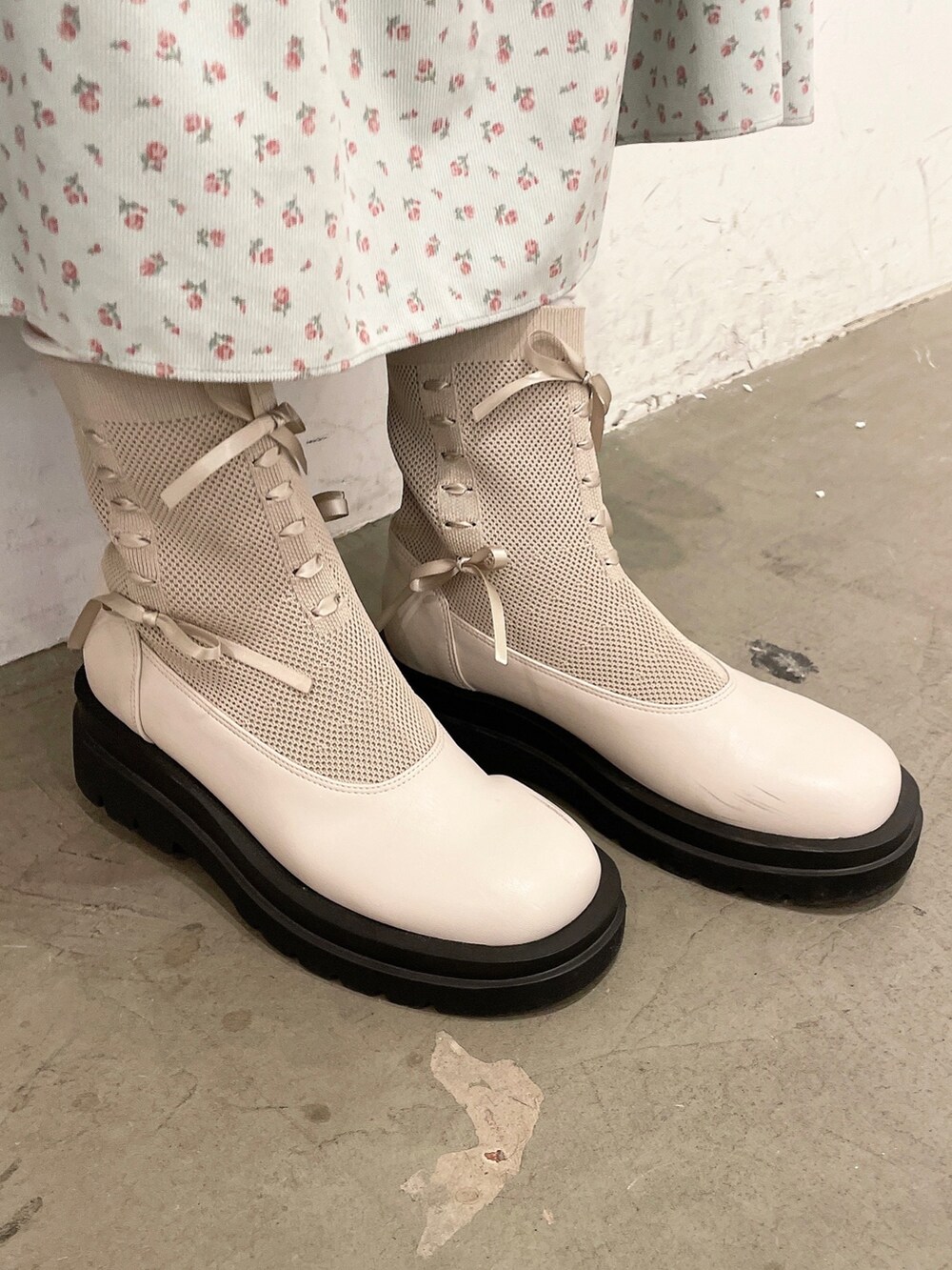 ホワイト系のシャツ/ブラウス、グリーン系のジャンパースカート、ホワイト系のブーツを着用したレディースの秋コーディネートの4枚目の写真