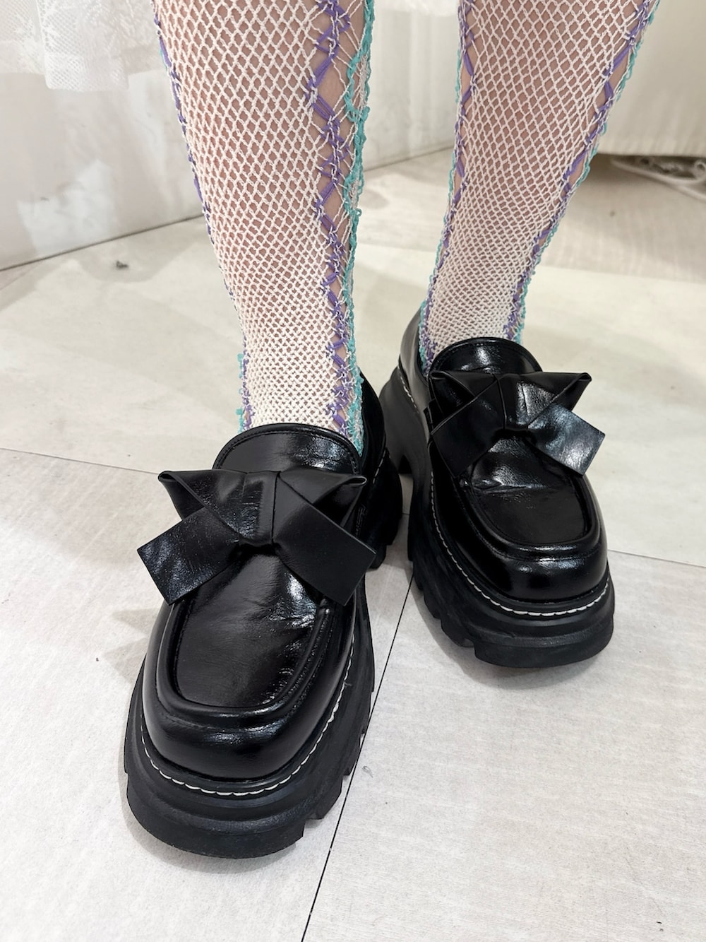 ホワイト系のダウンジャケット/コート、グレー系のワンピース、ブラック系のローファーを着用したレディースの秋コーディネートの6枚目の写真