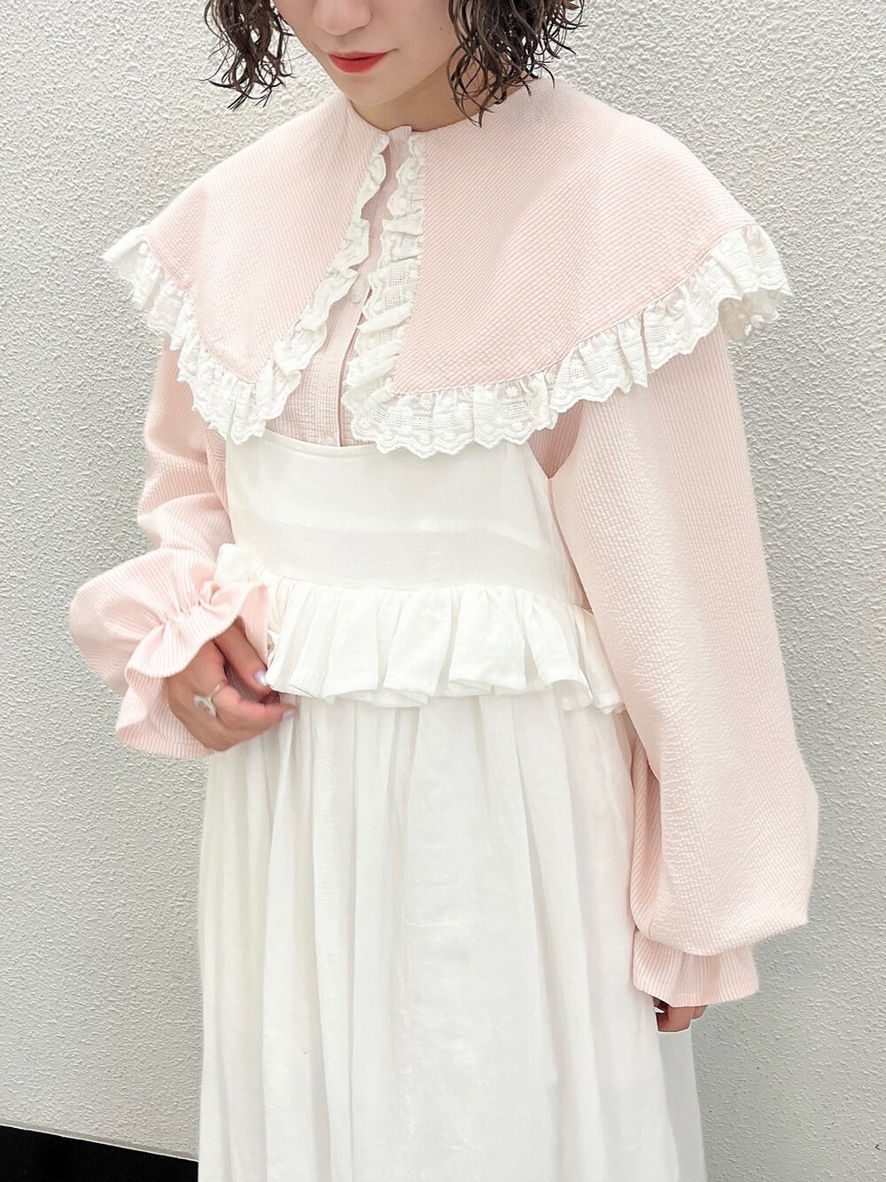 ピンク系のシャツ/ブラウス、ホワイト系のスカート、ピンク系のパンプスを着用したレディースの春コーディネートの6枚目の写真