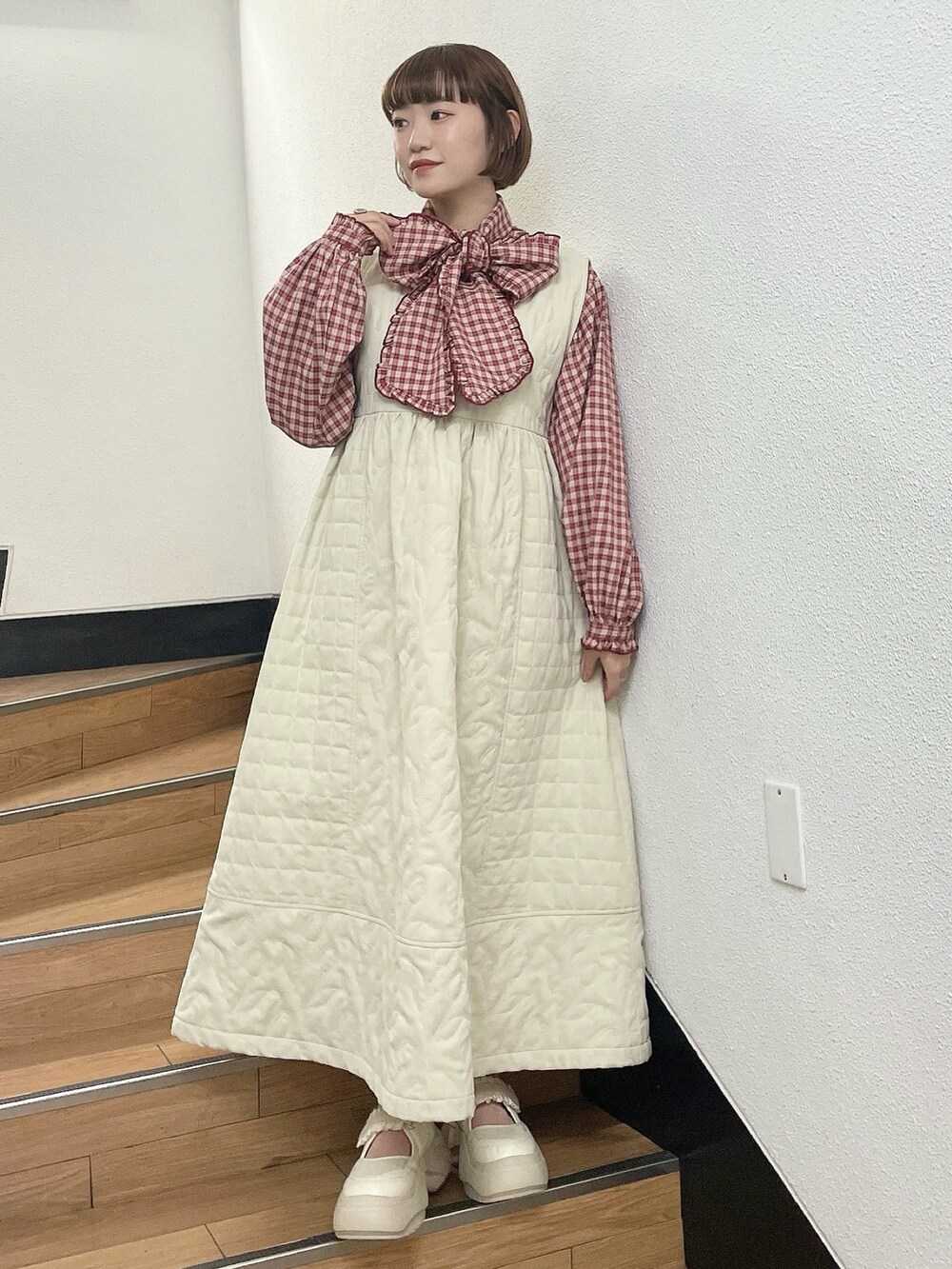 ホワイト系のダウンジャケット/コート、レッド系のシャツ/ブラウス、ホワイト系のワンピースを着用したレディースの冬コーディネートの8枚目の写真