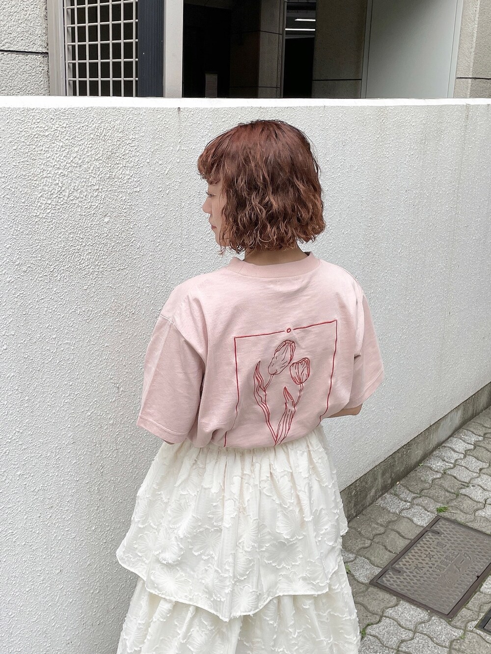 ピンク系のTシャツ/カットソー、ホワイト系のスカート、ピンク系のパンプスを着用したレディースの春コーディネートの5枚目の写真