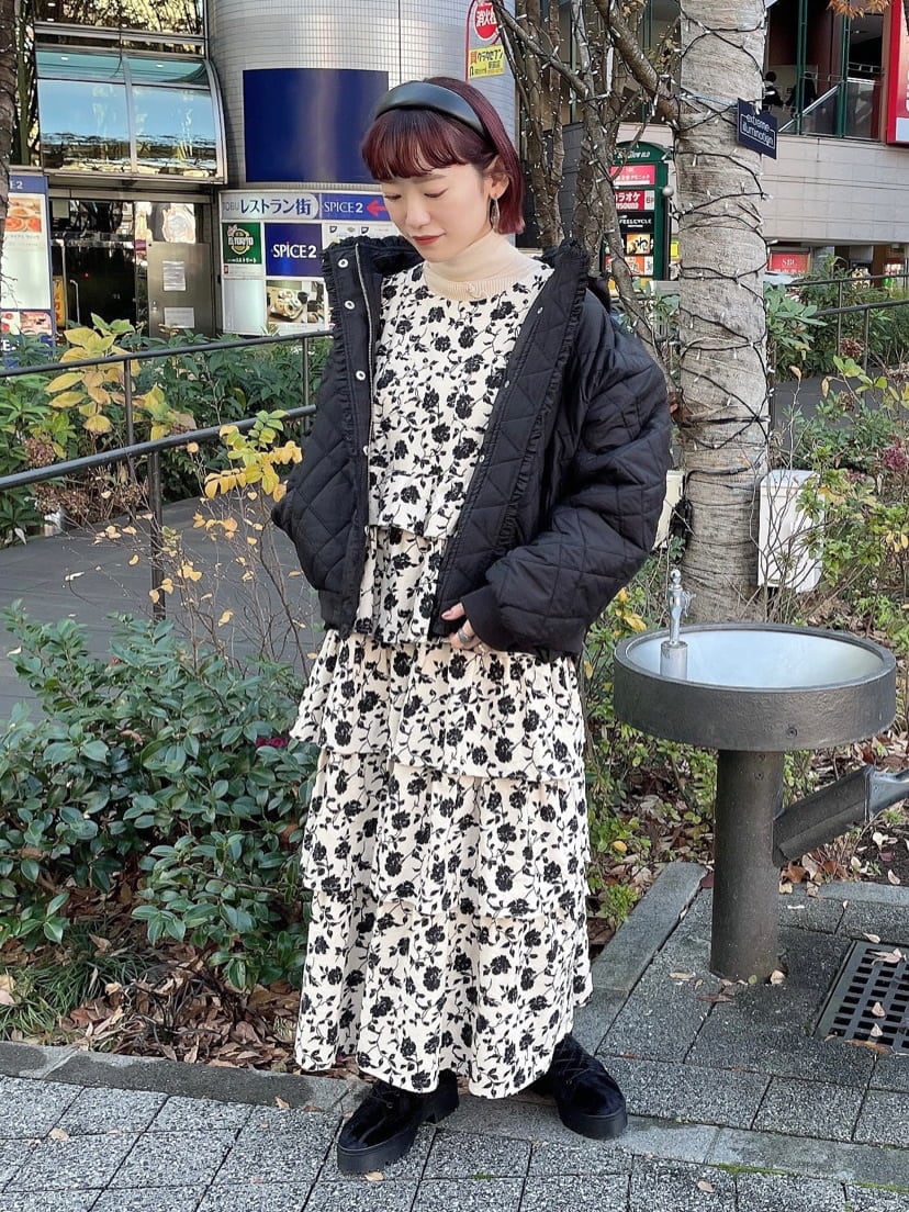 ブラック系のブーツ、ブラック系のナイロンジャケット、ホワイト系のジャンパースカートを着用したレディースの冬コーディネートの2枚目の写真