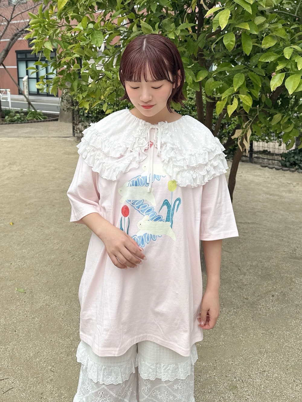 ピンク系のTシャツ/カットソー、ホワイト系のかごバッグ、ホワイト系のスニーカーを着用したレディースの春コーディネートの5枚目の写真