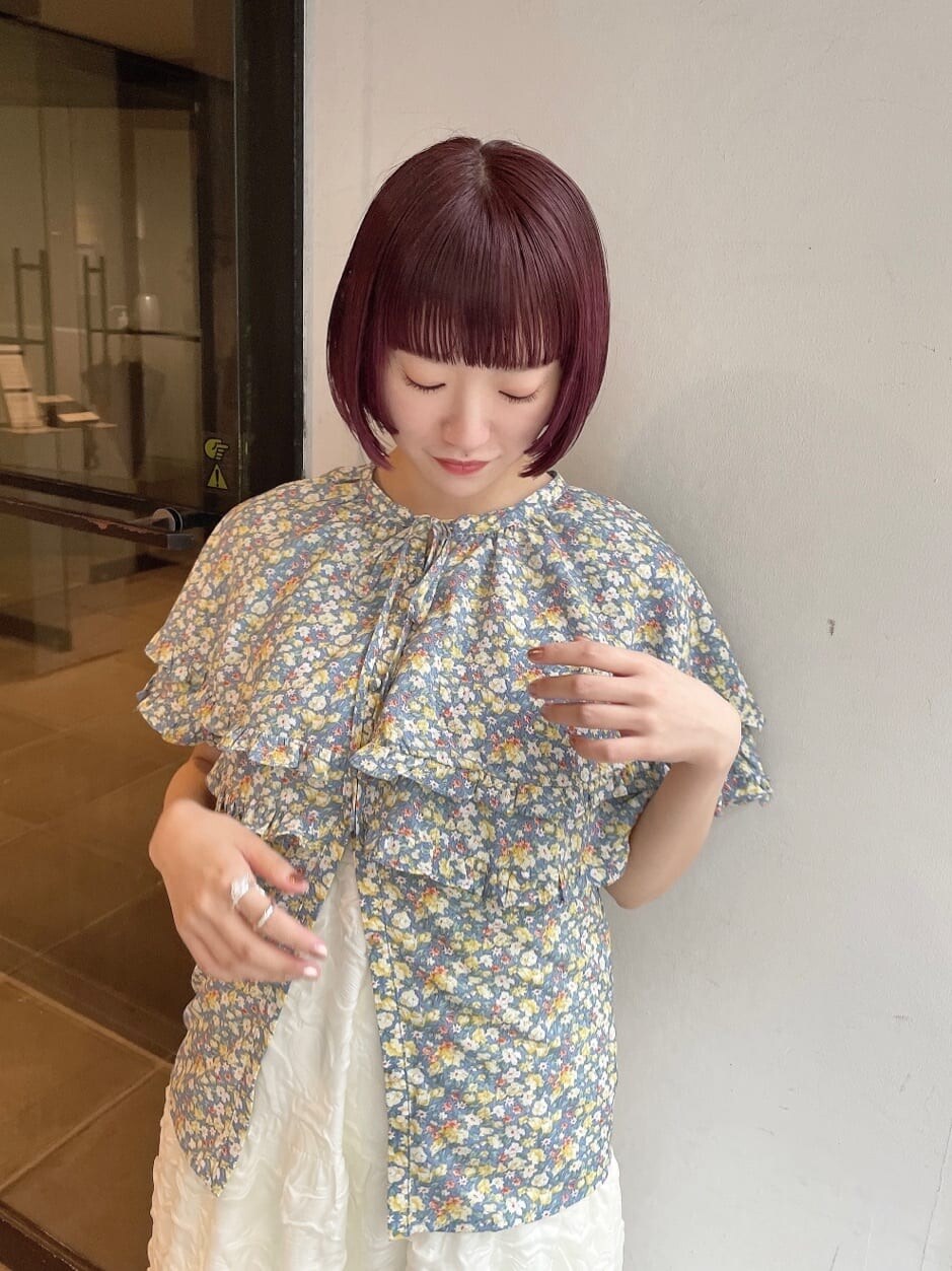 ホワイト系のワンピース、イエロー系のシャツ/ブラウス、オレンジ系のパンプスを着用したレディースの春コーディネートの4枚目の写真