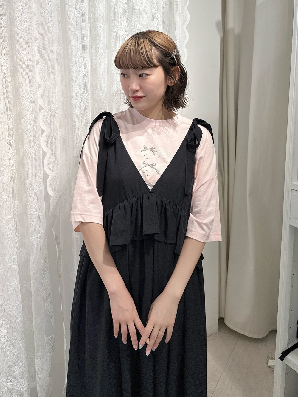 ピンク系のTシャツ/カットソー、ブラック系のワンピース、ブラック系のサンダルを着用したレディースの春コーディネートの4枚目の写真