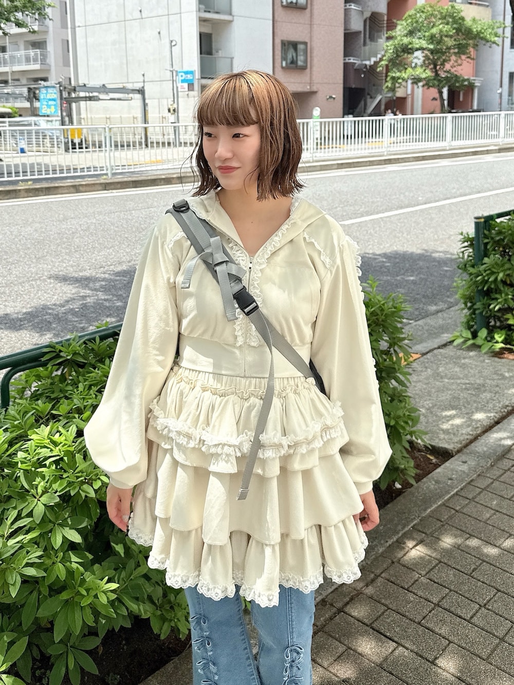 ブルー系のデニムパンツ、ホワイト系のスカート、ホワイト系のパーカーを着用したレディースの春コーディネートの4枚目の写真