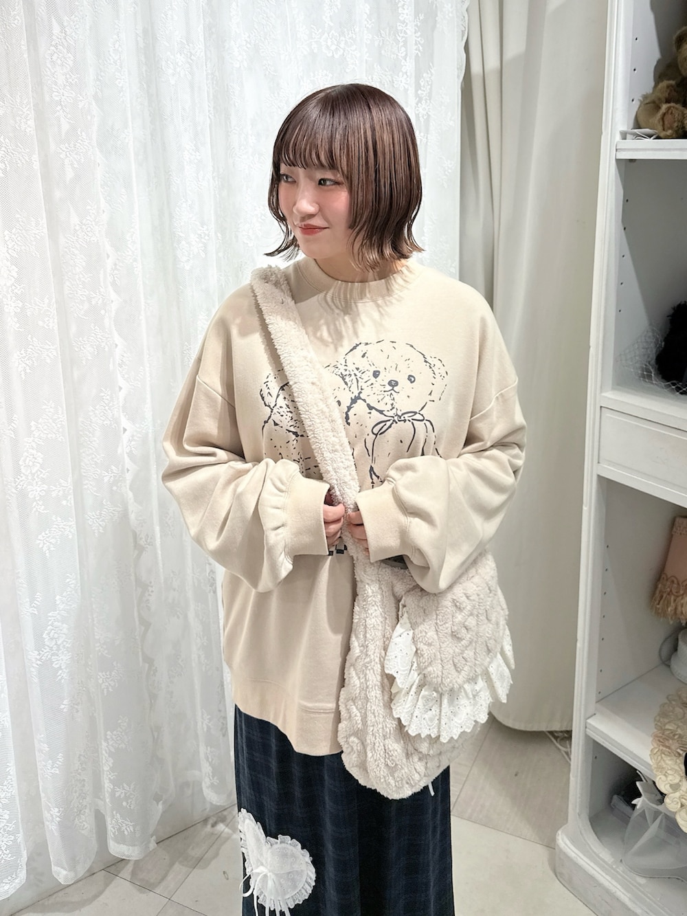 ベージュ系のスウェット、ベージュ系のショルダーバッグ、グリーン系のスカートを着用したレディースの秋コーディネートの6枚目の写真