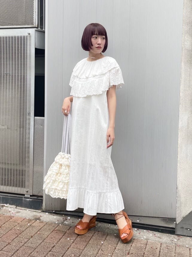 ホワイト系のワンピース、ブラウン系のサンダル、ホワイト系のトートバッグを着用したレディースの春コーディネートの2枚目の写真