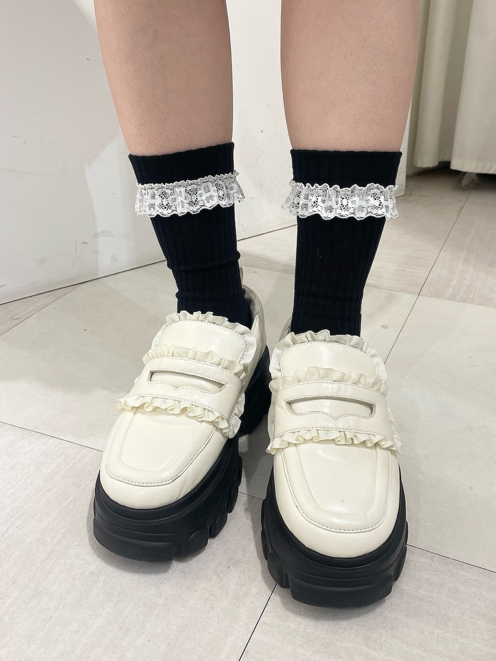 ホワイト系のブルゾン、ブラック系のワンピース、ホワイト系のローファーを着用したレディースの秋コーディネートの10枚目の写真