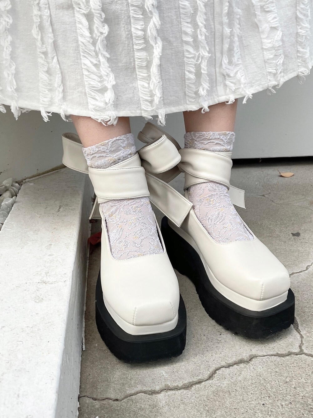 ブルー系のトレンチコート、ホワイト系のシャツ/ブラウス、ホワイト系のパンプスを着用したレディースの秋コーディネートの7枚目の写真