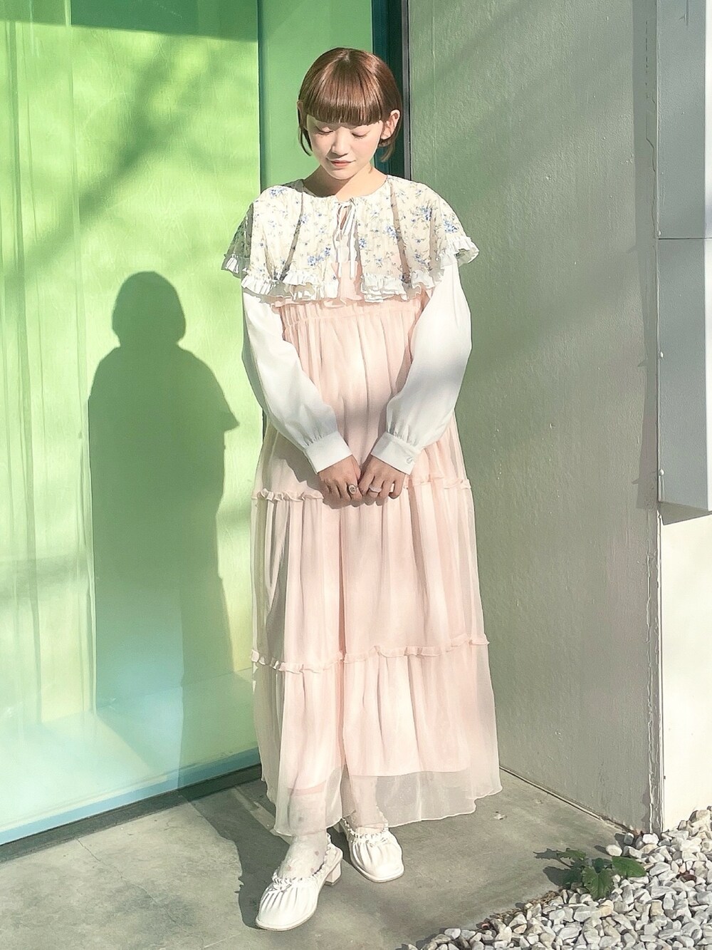 ブルー系のシャツ/ブラウス、ピンク系のワンピース、ホワイト系のパンプスを着用したレディースの春コーディネートの2枚目の写真