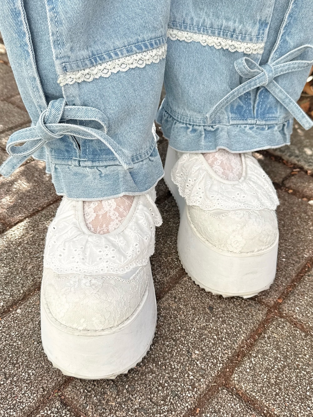 ピンク系のシャツ/ブラウス、グレー系のメッセンジャーバッグ、ブルー系のデニムパンツを着用したレディースの冬コーディネートの7枚目の写真