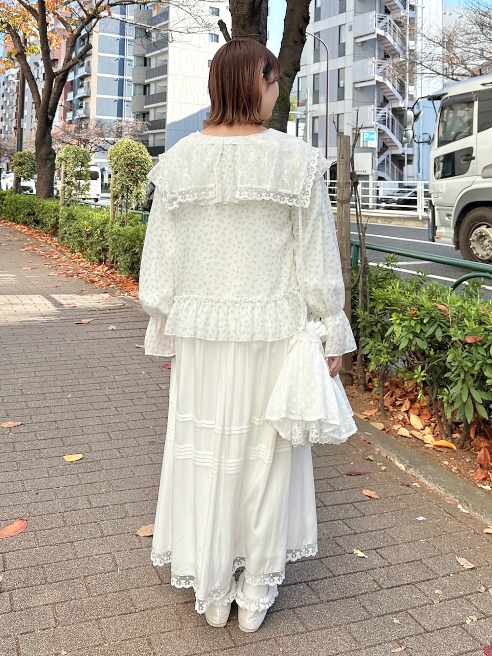 ホワイト系のワンピース、ブルー系のカーディガン/ボレロ、ホワイト系のショルダーバッグを着用したレディースの冬コーディネートの3枚目の写真