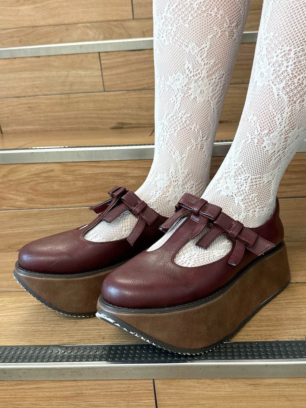 レッド系のスウェット、グレー系のスカート、ブラウン系のハンドバッグを着用したレディースの夏コーディネートの8枚目の写真