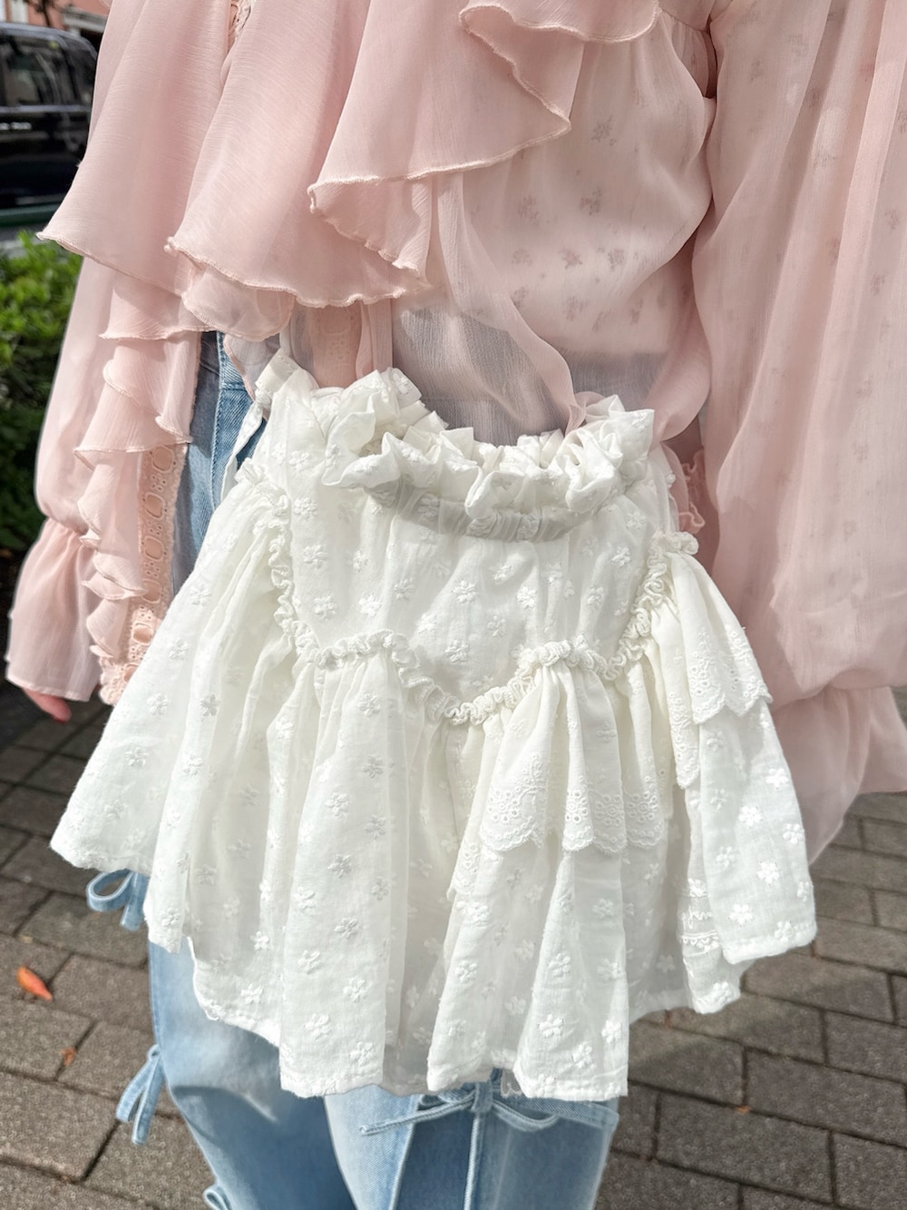 ピンク系のカーディガン/ボレロ、ピンク系のTシャツ/カットソー、ホワイト系のショルダーバッグを着用したレディースの秋コーディネートの7枚目の写真